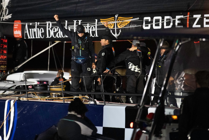 Crew pump fists on a yacht at night.