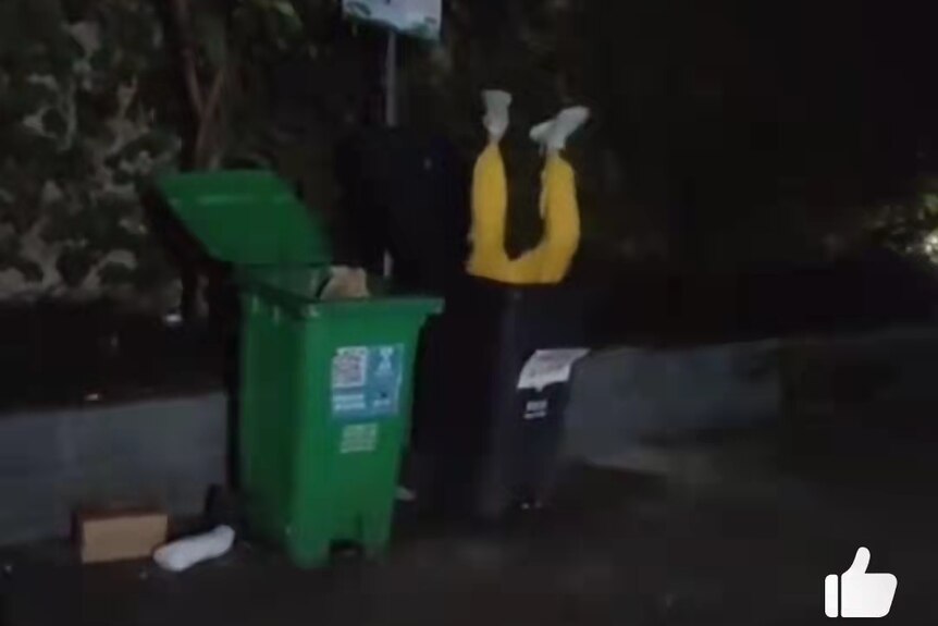 一名男子在垃圾桶倒立。