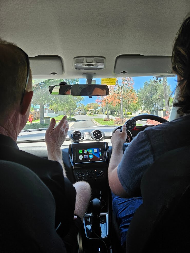 A driving instructor pictured with a learner driver behind the wheel