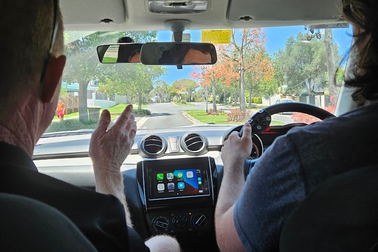 A driving instructor pictured with a learner driver behind the wheel