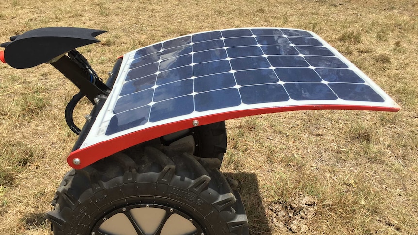 Small robot powered by solar panels, on two wheels with a helmet shaped scanner