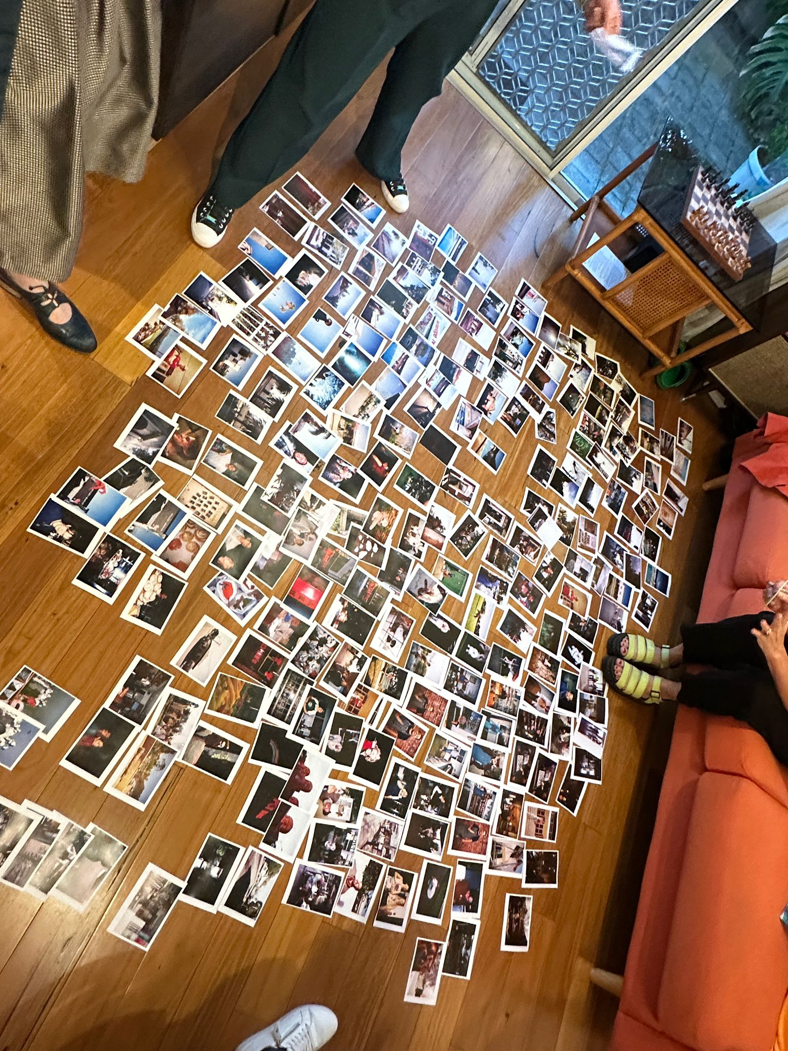 Decenas de fotografías se encuentran en hileras sobre el suelo de madera del salón.