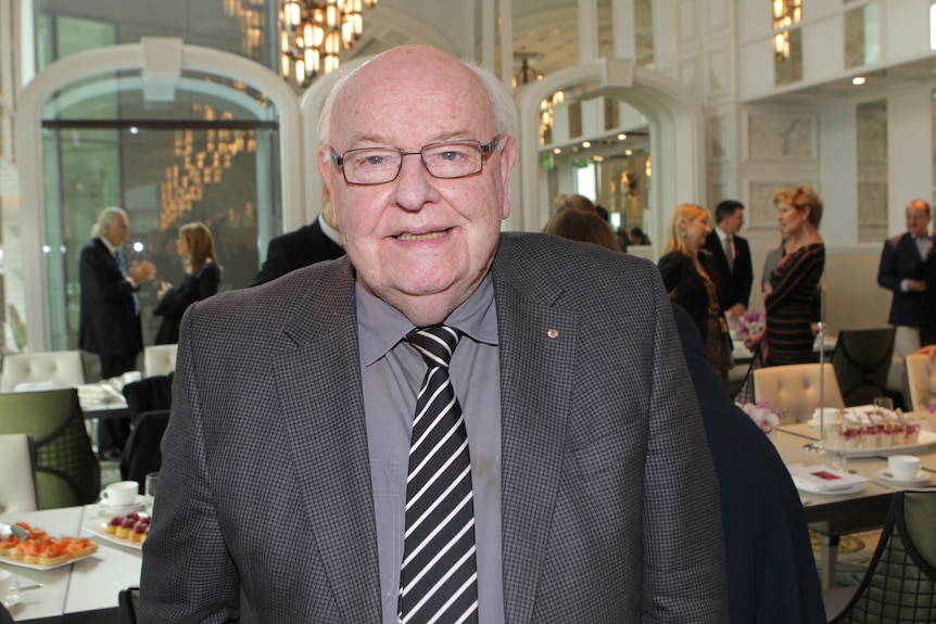 A man in a suit at a dinner function