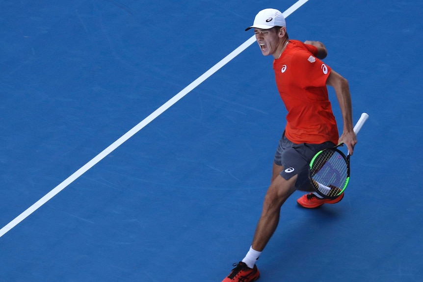 Alex De Minaur pumps his fist as he celebrates a win over Pedro Sousa at the Australian Open