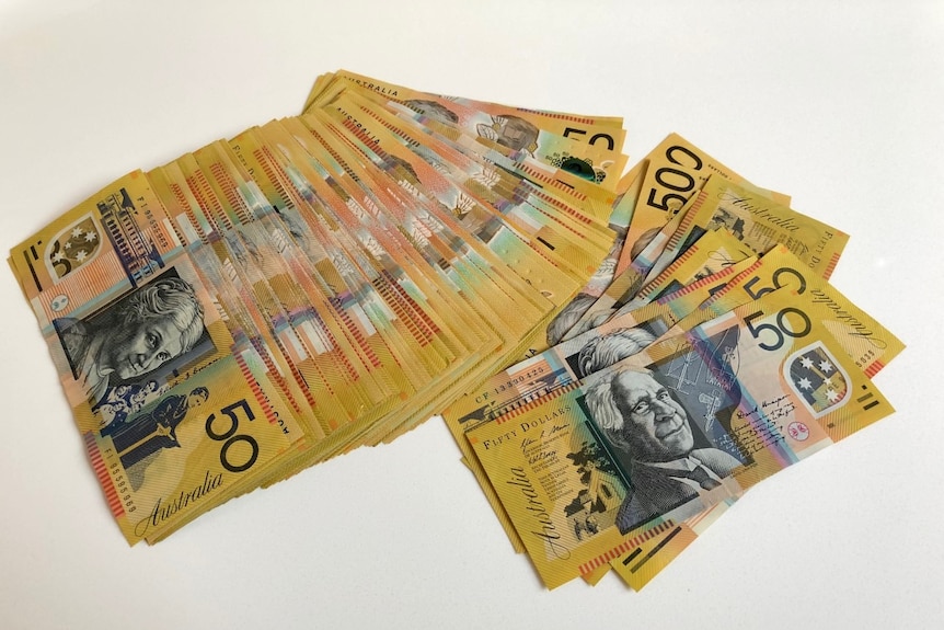 A pile of $50 Australian notes on a white background.