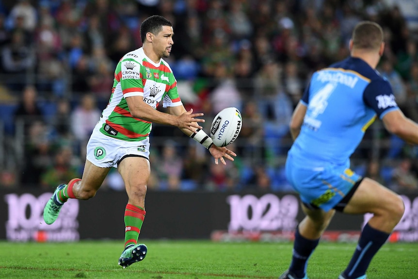 Cody Walker runs and passes the ball to his left for the Rabbitohs against the Titans.