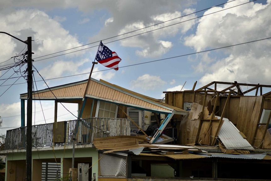 The top half of a double storey home is totally destroyed, the wooden frameworks collapsing