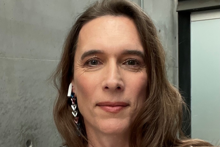 A woman wearing silver earrings