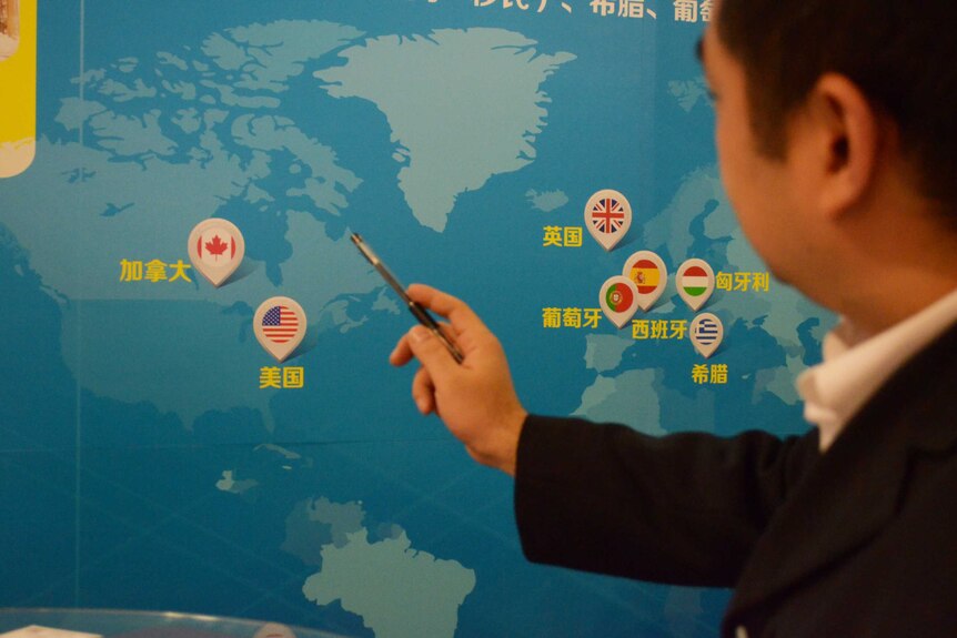 A businessman points to a map at an overseas property exhibition in Beijing