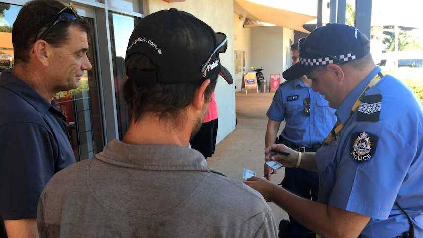 Two men have their ID checked as part of a police operation