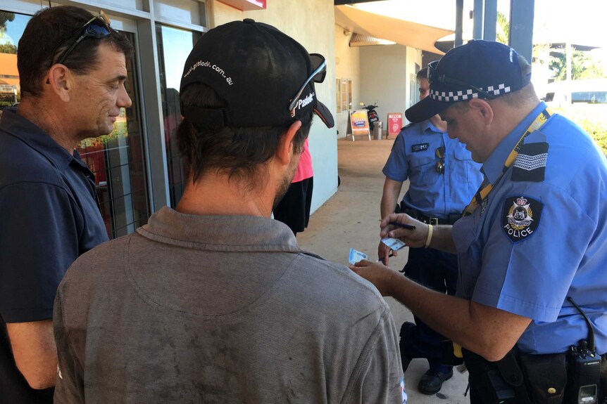 Two men have their ID checked as part of a police operation