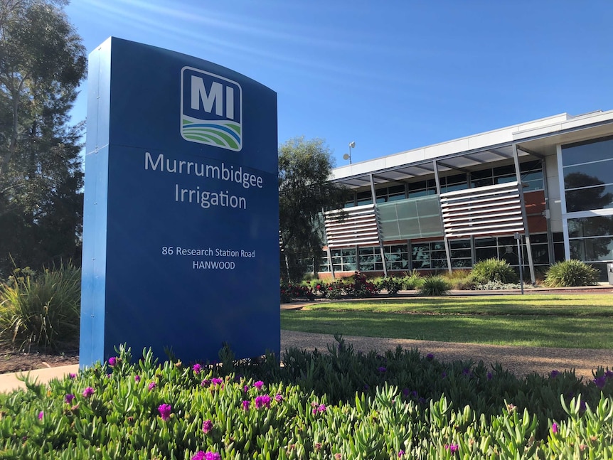 A blue sign reading 'Murrumbidgee Irrigation' stands in a garden out the front of a corporate-looking office building.