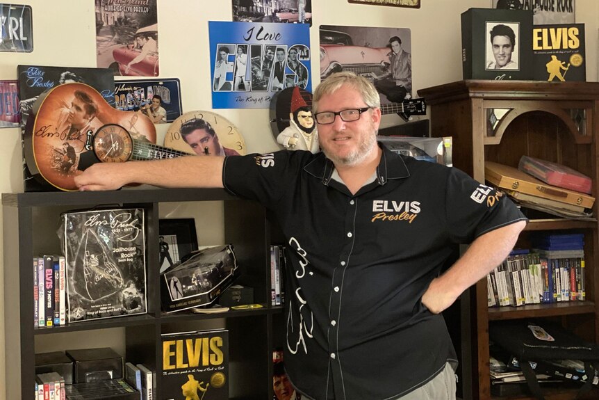 Joshua Clarke standing with part of his collection of Elvis Presley memorabilia