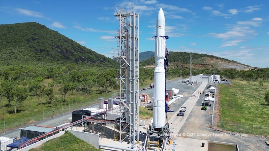 A large rocket being rolled onto a launch pad horizontally and then stood up