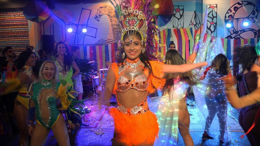 A woman in a brightly coloured Carnivale-style costume.