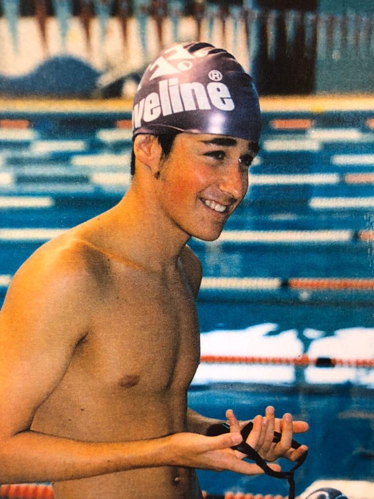 A smiling young man in swimming cap.