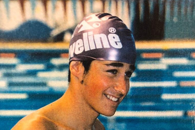 A smiling young man in swimming cap.