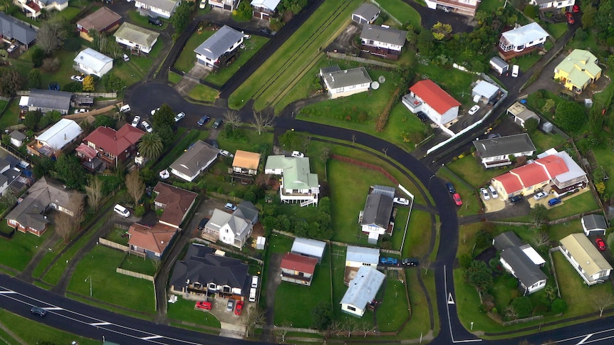 Residential houses can be seen along a road in a suburb of Auckland in New Zealand.