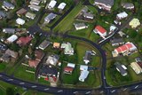 Residential houses can be seen along a road in a suburb of Auckland in New Zealand.