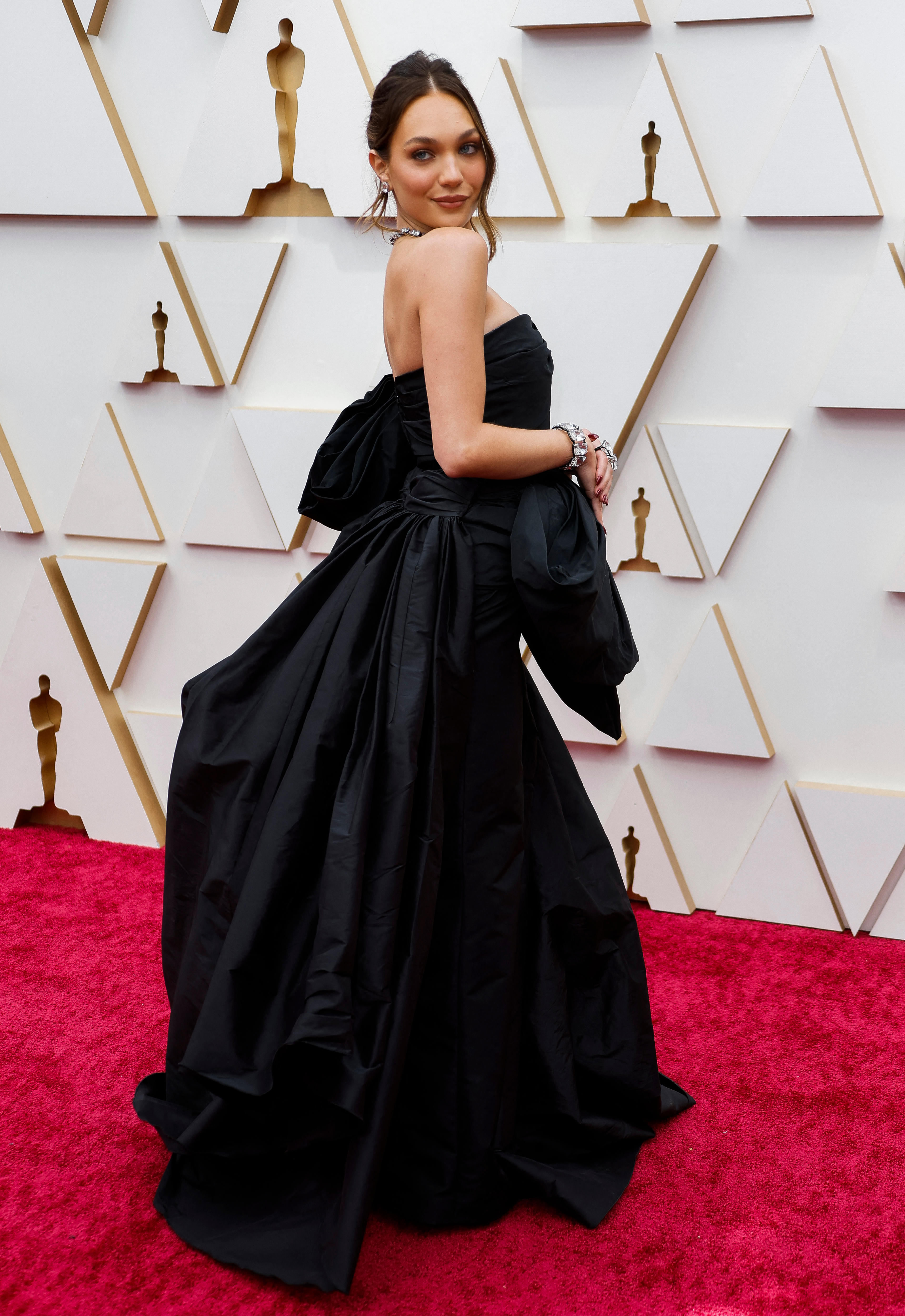 maddie ziegler poses on the oscars red carpet in a black billowing dress