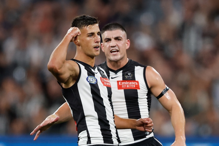 A Collingwood AFL player pumps his fist after kicking a goal.