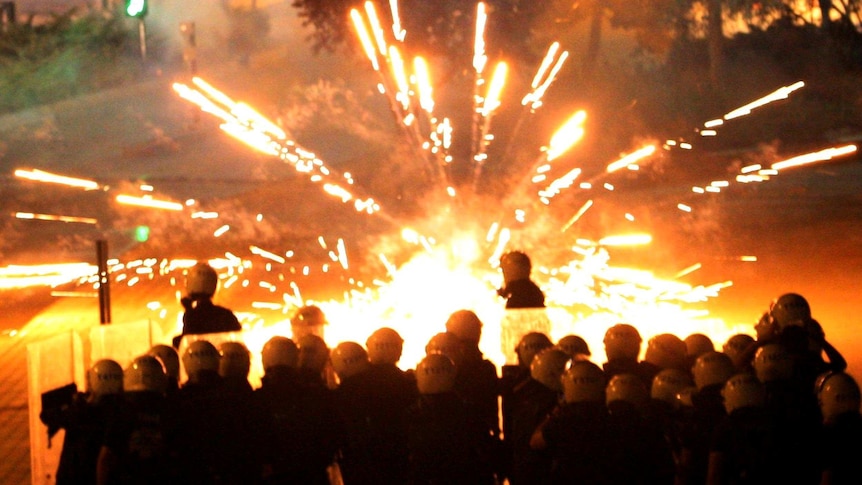 Turkish police stand in front of fireworks thrown by demonstrators.