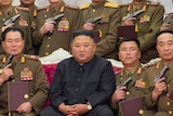 A photo of Kim Jong-un surrounded by soldiers brandishing hand guns