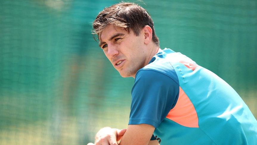 Australian cricketer Pat Cummins looks lost in thought as he sits at a training session.