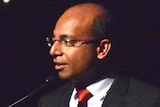 Adani CEO Jeyakumar Janakaraj speaks at a podium.