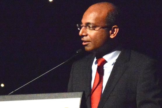 Adani CEO Jeyakumar Janakaraj speaks at a podium.