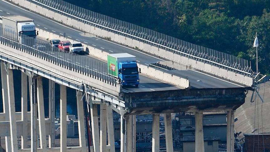 A truck on the edge of collapsed bridge.
