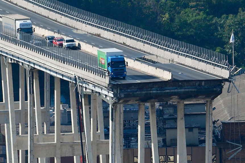 A truck on the edge of collapsed bridge.