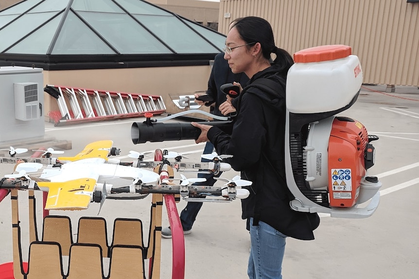 A woman sprays a drone