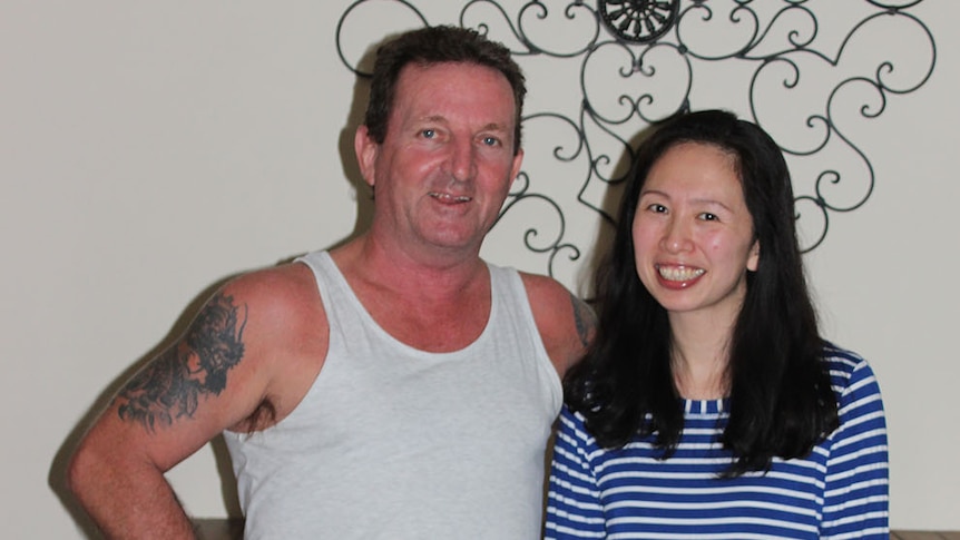 Lawrence Downey and Amy Chen stand together in a hallway in a house in Rockhamption