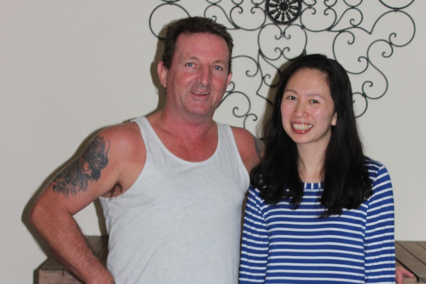 Lawrence Downey and Amy Chen stand together in a hallway in a house in Rockhamption