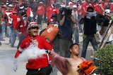 Violence: a Red Shirt protester throws a tear gas canister at soldiers amid deadly clashes in April