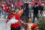 Violence: a Red Shirt protester throws a tear gas canister at soldiers amid deadly clashes in April