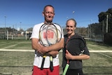 A man smiles holding a tennis racquet on a court next to a woman holding a racquet