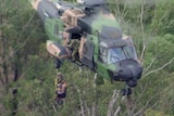 A helicopter carries two people to safety
