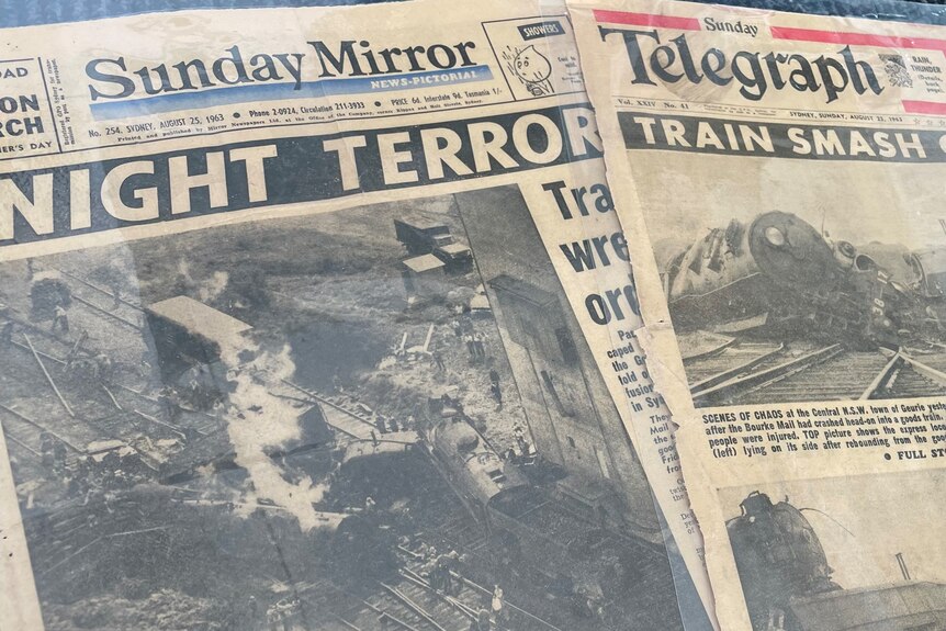 Two old newspapers showing photos of the crash