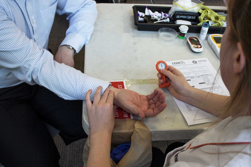 A nurse taking an unidentified man's pulse.