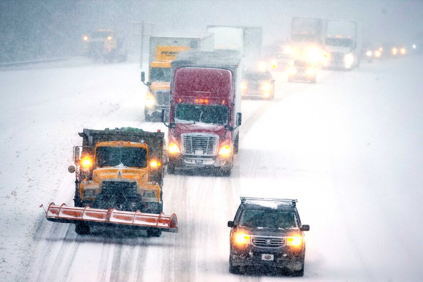 Several trucks and cars with their headlights on make their way slowly down the I-85 in Lexington, North Carolina.