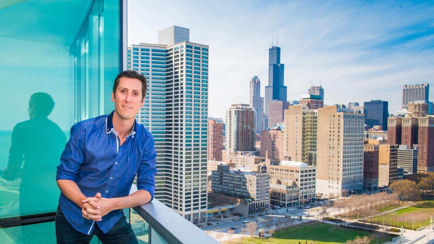 Australian expat Morgan Roy stands on the balcony of his Chicago apartment.