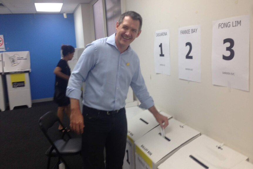 Michael Gunner puts his ballot in a voting box.