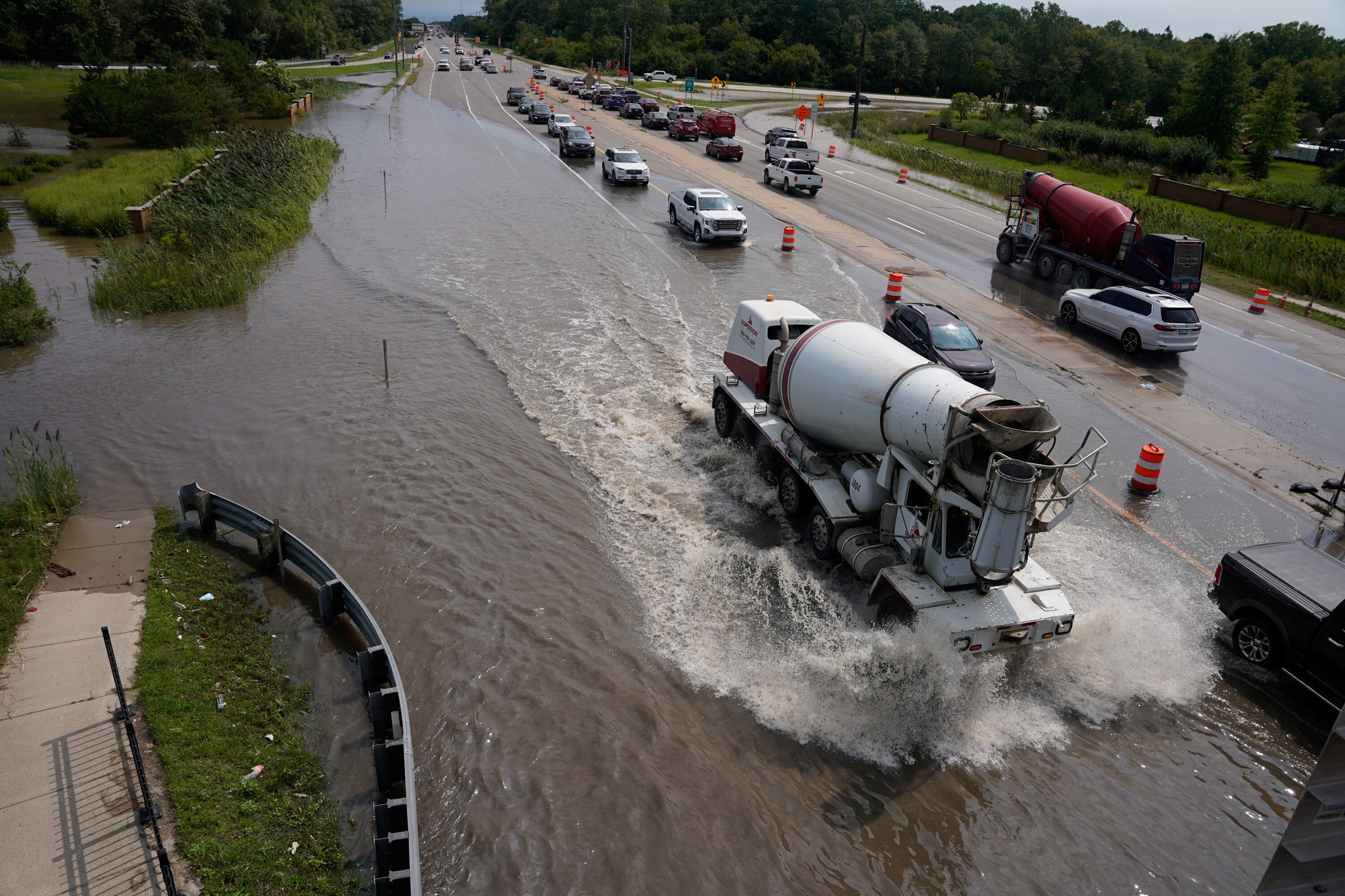 A truck and other cars driving through a flooded road