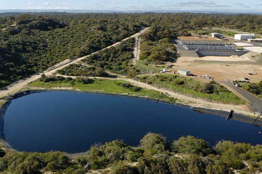 An aerial shot of a large lake of water near a waste water treatment facility.