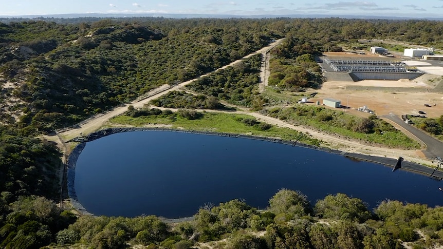 An aerial shot of a large lake of water near a waste water treatment facility.