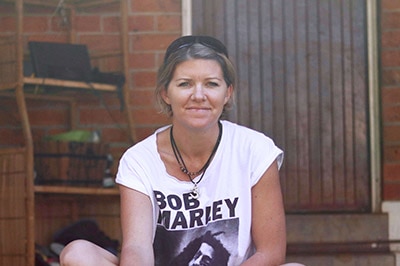 Woman on verandah with blue healer dog.