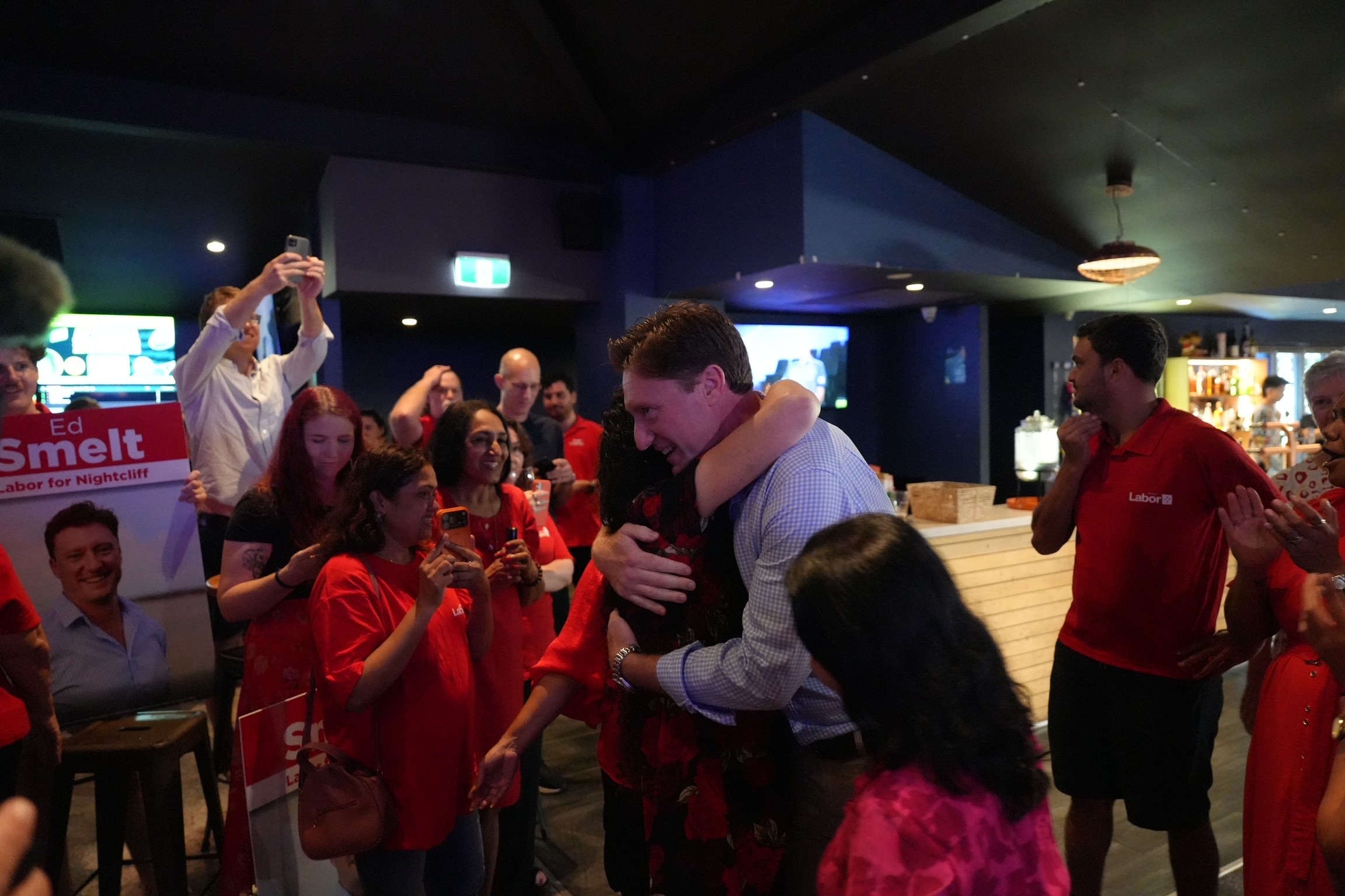 Ed abraza a una mujer en un bar mientras los fanáticos aplauden