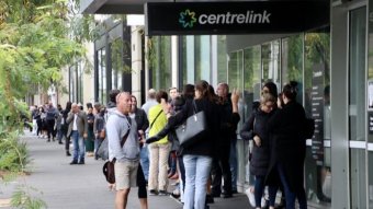 A queue of people stretches down York Street in South Melbourne, starting at the entrance to a Centrelink building.